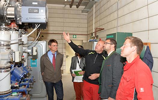 Mitarbeiter der Heppdieler Bioenergie-GmbH UZZOG erklären Landwirtschaftsamtsleiter Klaus Bernhart und Landrat Jens Marco Scherf (von links), wie Wärme erzeugt und in die Haushalte weitergeleitet wird.