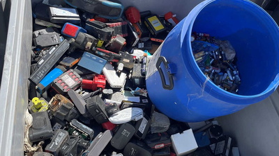 Diverse lose Akkus und Batterien in einem Container