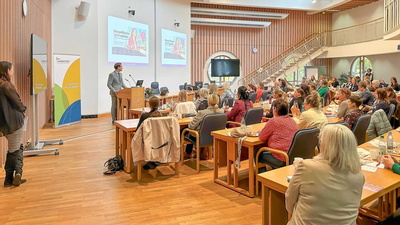 Teilnehmende beobachten die Präsentation