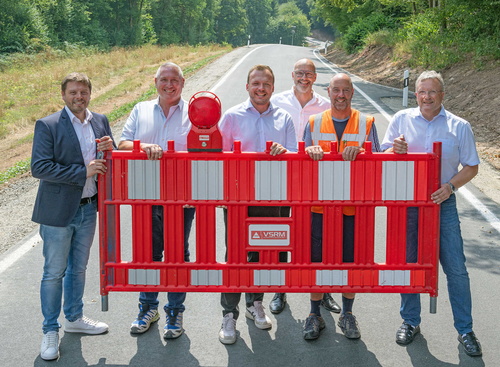 6 Männer halten Absperrung hoch