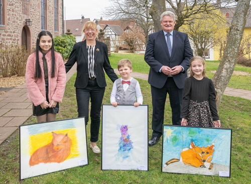 Drei Gewinnerkinder mit ihren gemalten Werken, der stellvertretender Landrätin Monika Wolf-Pleßmann und Eschaus Bürgermeister Gerhard Rüth