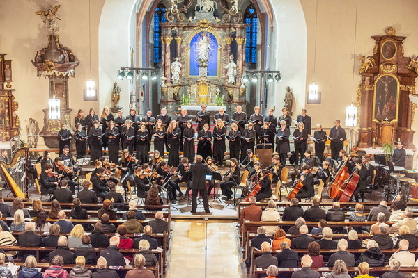 Ensemble spielt vor Zuschauern in einer Kirche
