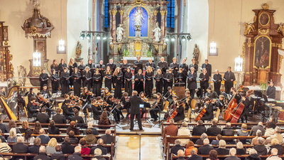Ensemble spielt vor Zuschauern in einer Kirche