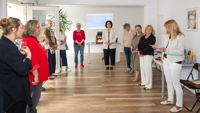 Mehrere Frauen stehen im Kreis in einem Raum