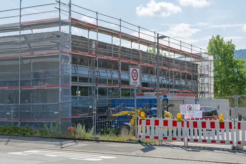 Ein Schulgebäude ist mit einem Baugerüst verhüllt
