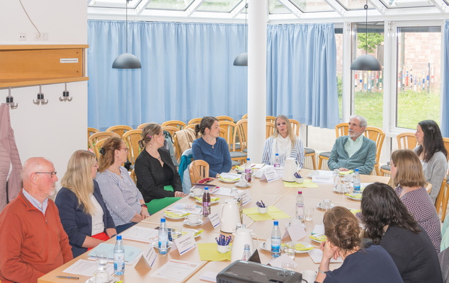 Viele Menschen die um einen tisch sitzen