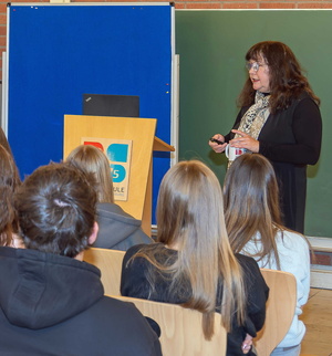 Birigt Mair hält vor mehreren Schülerinnen und Schülern einen Vortrag zu den Gefahren des Rechtsextremismus