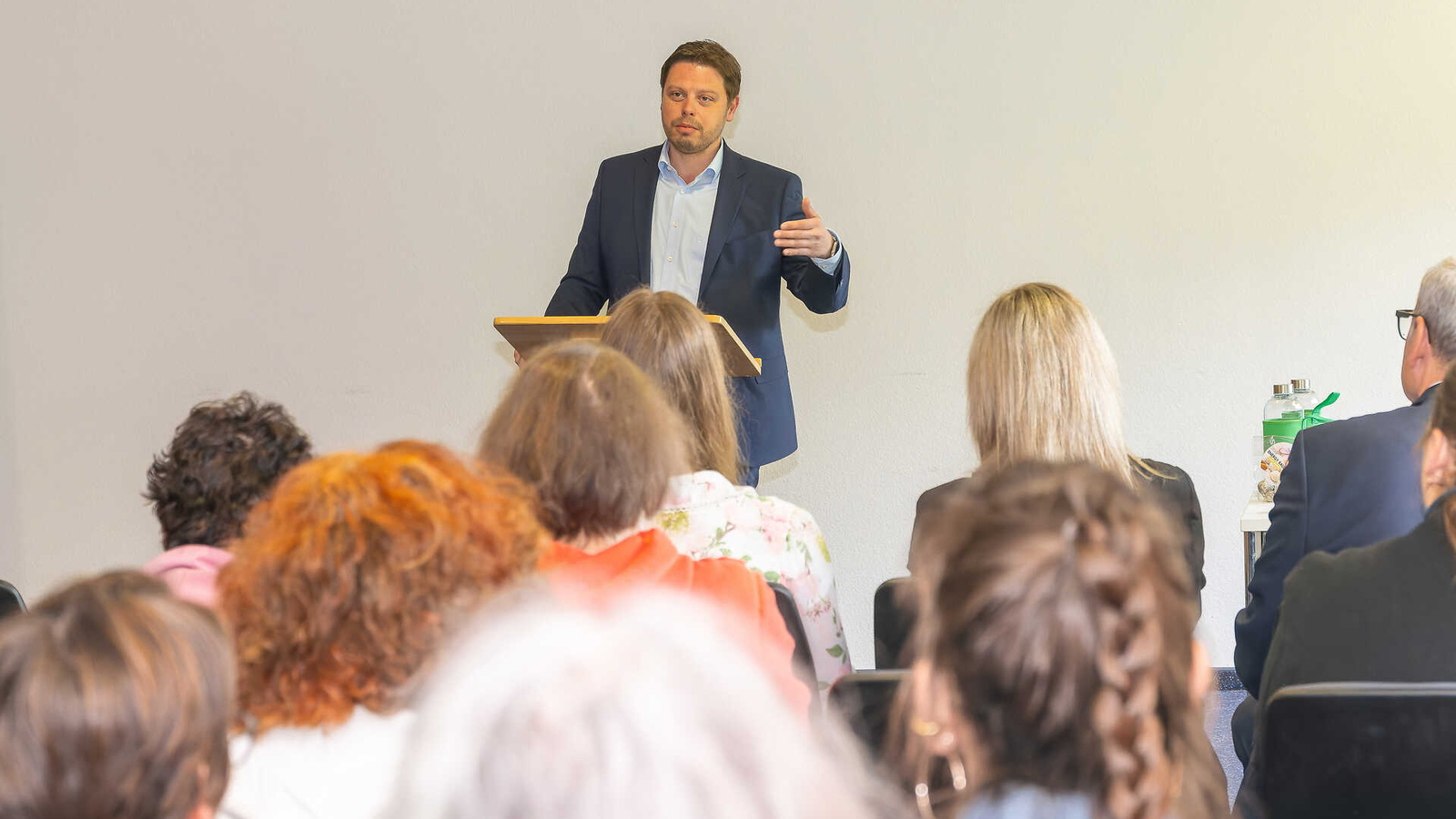 Landrat Björn Bartels hält einen Vortrag vor Zuschauenden