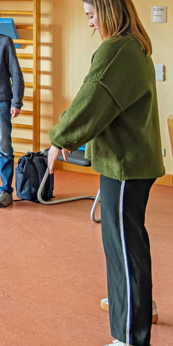 Einen Frau zeigt wie man im Stehen seinen Rücken entlasten kann.