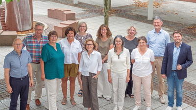 Eine Personengruppe steht zum gemeinsamen Foto zusammen
