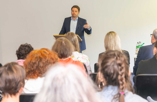 Landrat Björn Bartels hält einen Vortrag vor Zuschauenden