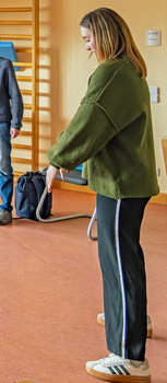Einen Frau zeigt wie man im Stehen seinen Rücken entlasten kann.
