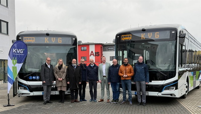 Menschen vor zwei Elektrobussen