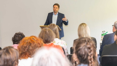 Landrat Björn Bartels hält einen Vortrag vor Zuschauenden