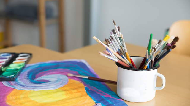 Becher mit Pinseln und selbst gemalten Bild