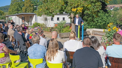 Menschen sitzen vor Bühne im Freien