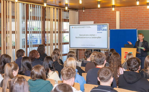 Stellvertreterin des Landrats, Monika Wolf-Pleßmann referiert vor einigen Schülerinnen und Schülern mit Hilfe einer digitalen Präsentation