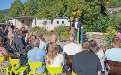 Menschen sitzen vor Bühne im Freien