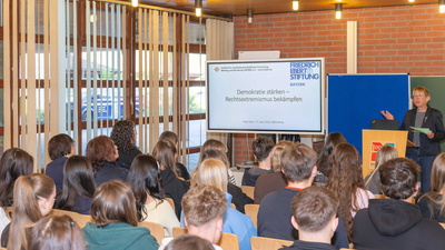 Stellvertreterin des Landrats, Monika Wolf-Pleßmann referiert vor einigen Schülerinnen und Schülern mit Hilfe einer digitalen Präsentation