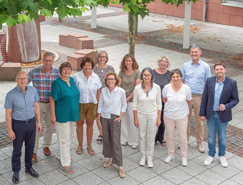 Eine Personengruppe steht zum gemeinsamen Foto zusammen