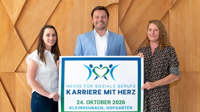 Drei Menschen halten ein Plakat zur Veranstaltung hoch