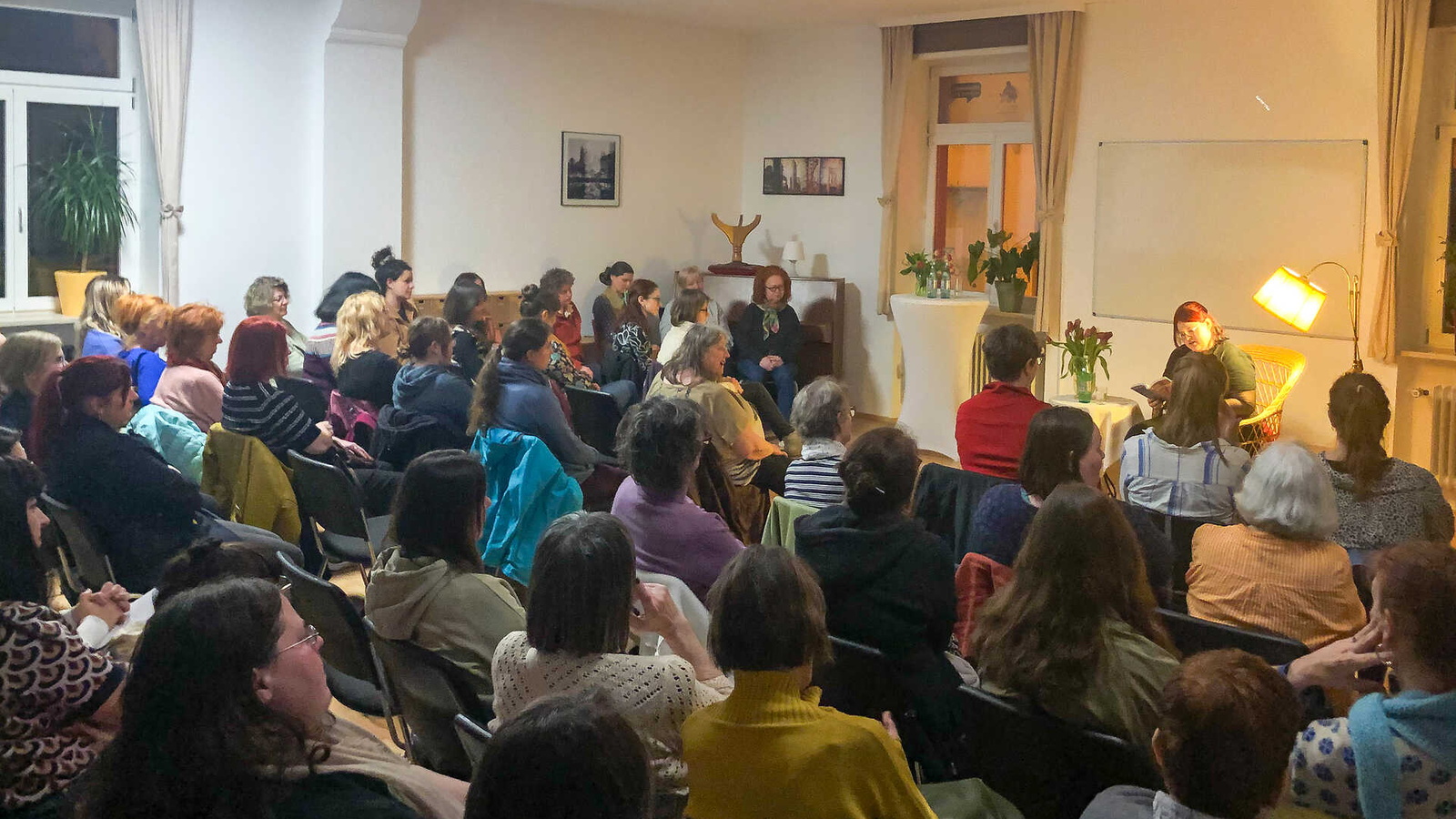 Menschen die bei einer Lesung zuhören