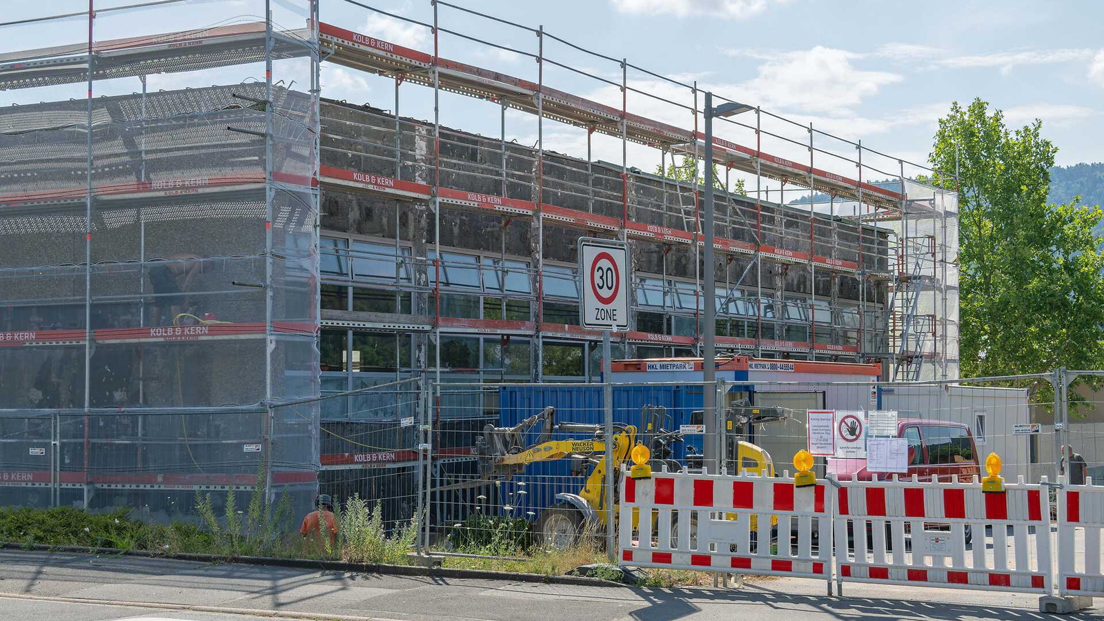 Ein Schulgebäude ist mit einem Baugerüst verhüllt