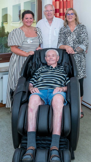 Ein Senior liegt in einem Massagestuhl